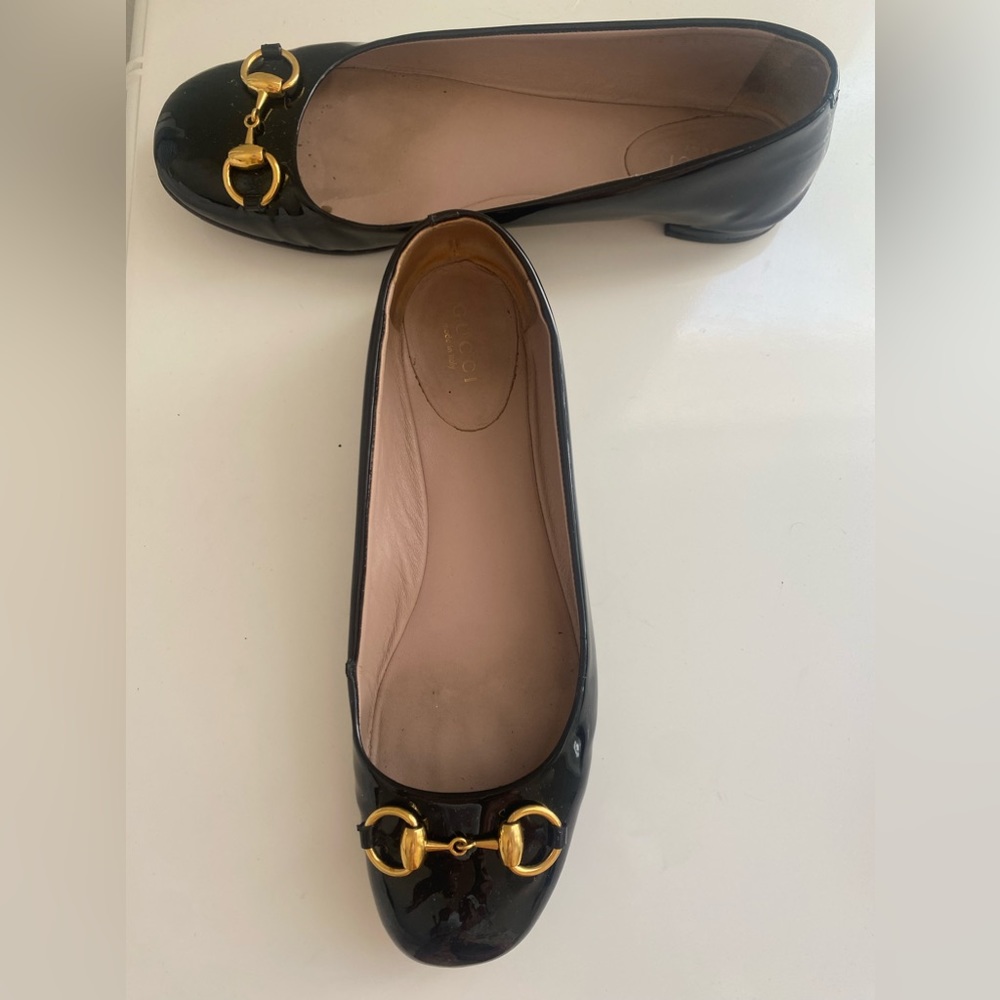 Gucci size 371/2 black patent ballet flats with gold hardware.